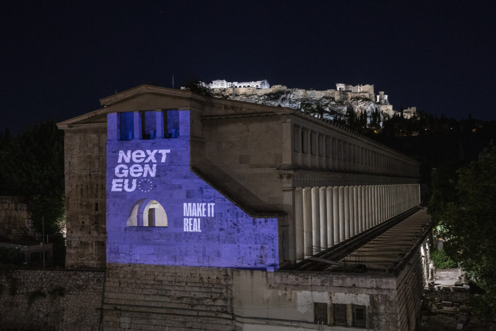 Antiikin rakennukseen heijastettu "Next Gen EU". Takana taitaa olla normaalisti valaistu Akropolis.  