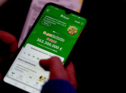 Käsi pitelee älypuhelinta, jonka näytöllä on auki Sisalin nettikasino. Vihreällä etusivulla näkyy SuperEnalotton 363 300 000 euron jackpot ja seuraavan arvonnan ajankohta. Yläreunassa on SuperEnalotton 25-vuotisjuhlabanneri.