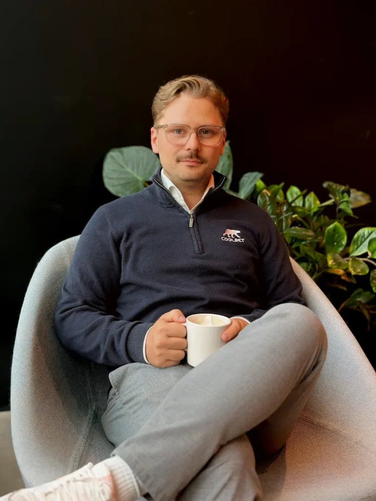 Coolbetin Joonas Hartikainen kuvattuna Coolbetin toimistolla kahvikuppi kädessä. 