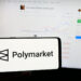 Polymarketin logo puhelimella, taustalla tietokoneen näytöllä auki Polymarket.