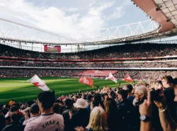 Täysi Emirates Stadium Valioliigaottelun alla. Arsenal-kannattajat täyttävät katsomot ja kentän laidalla liehuu seuran lippuja.