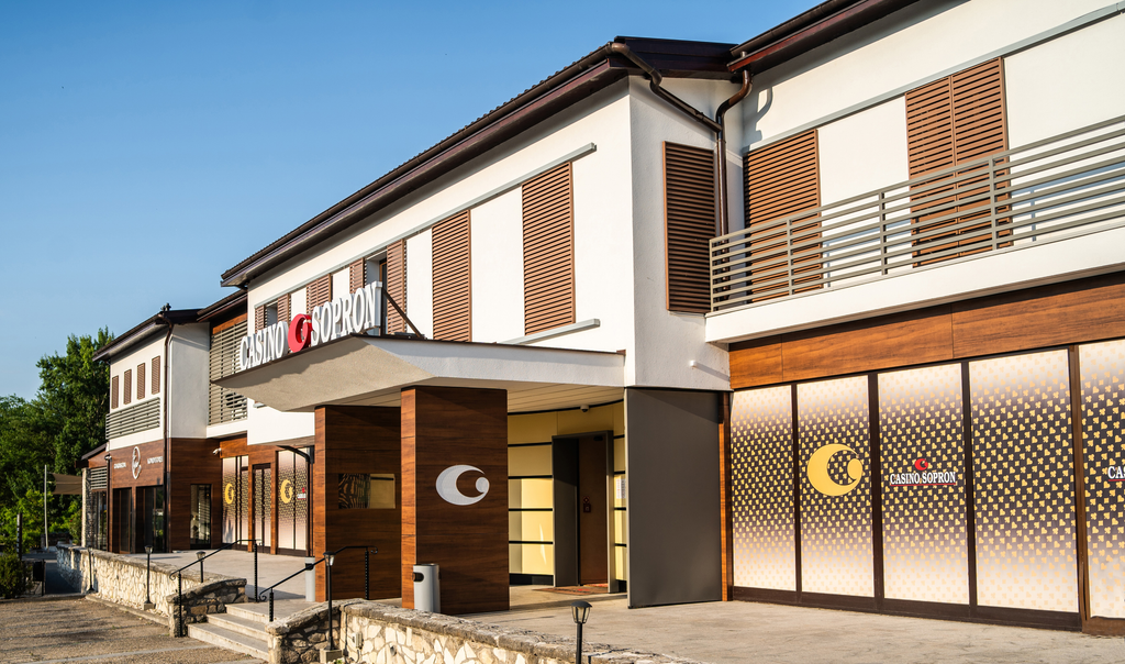 Casino Sopron ulkoseinä. Kaksikerroksinen vaatimaton rakennus. Taustalla viheralue.