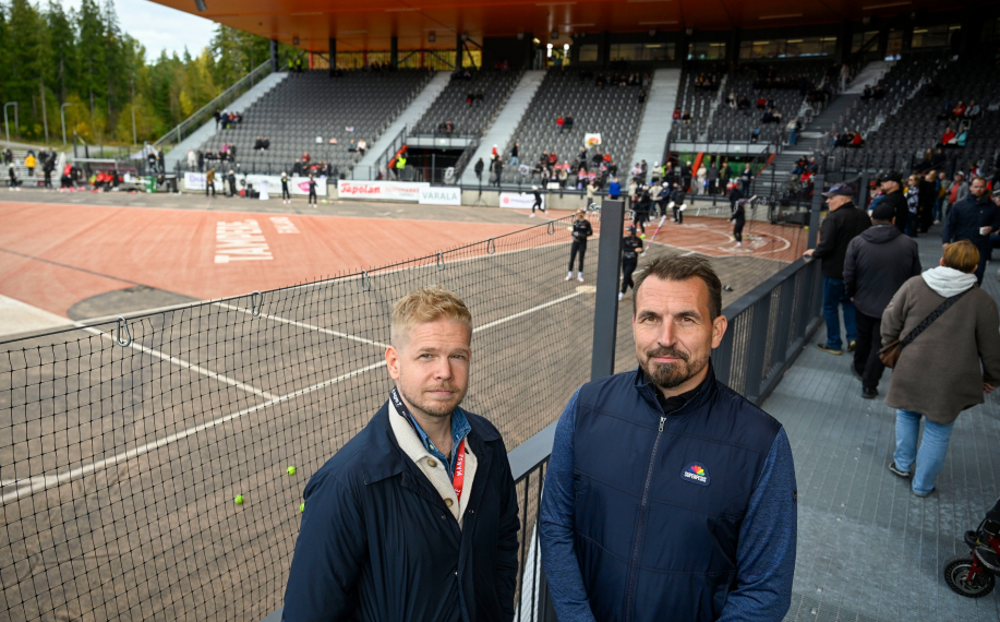 Joel Häkämies ja Vesa Karjalahti poseeraavat pesäpallostadionin katsomon edessä.