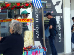 Mies pankkiautomaatilla. Etualalla katukoju.
