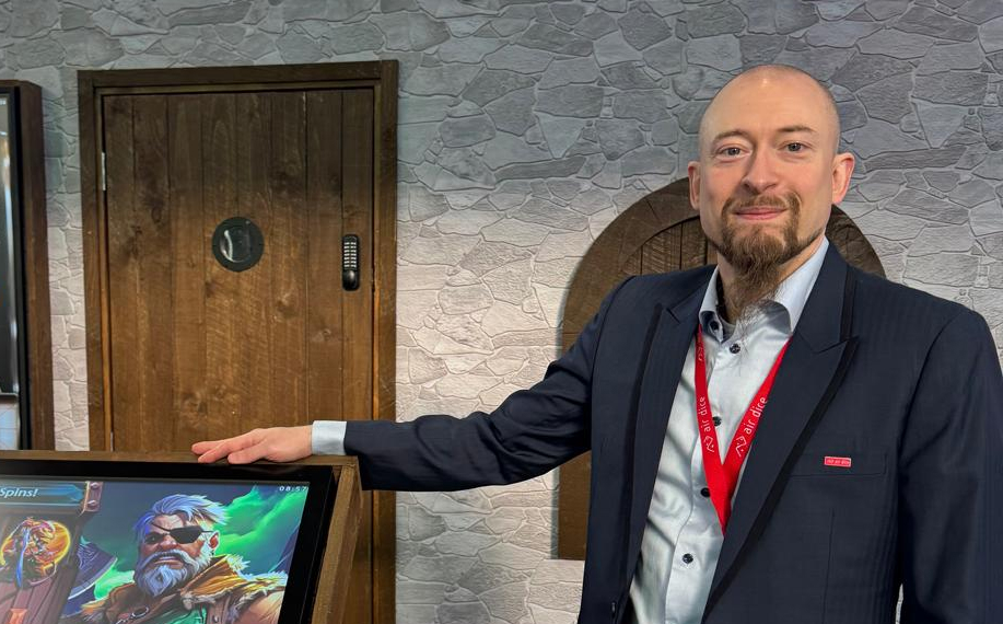 Sami Mäkinen poseeraa Air Dicen peliautomaatin kanssa.