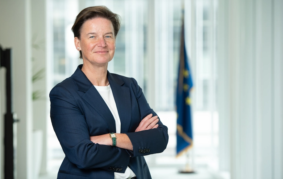 Verena Ross poseeraa EU-lipun edessä.